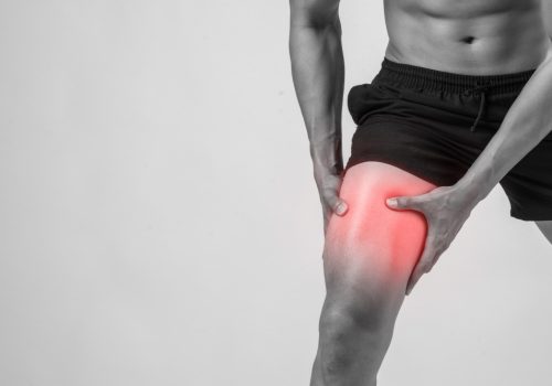 young-sport-man-with-strong-athletic-legs-holding-knee-with-his-hands-pain-after-suffering-ligament-injury-isolated-white